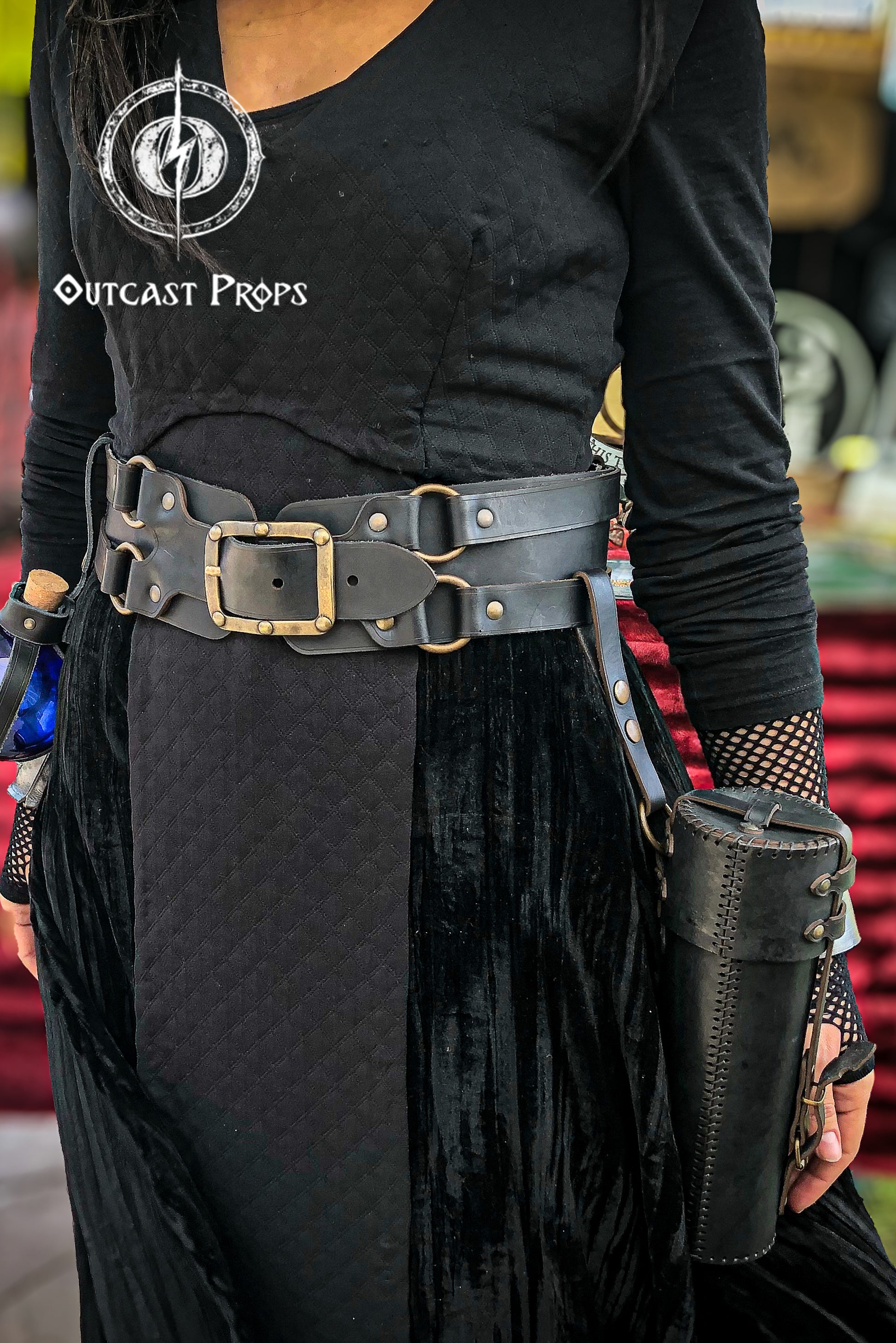 Person wearing a black outfit with a belt and holsters, featuring Outcast Props logo. Versatile Leather Belt Clasp for LARP, Cosplay & Medieval Accessories - Handcrafted Vegetal Tanned Attachment