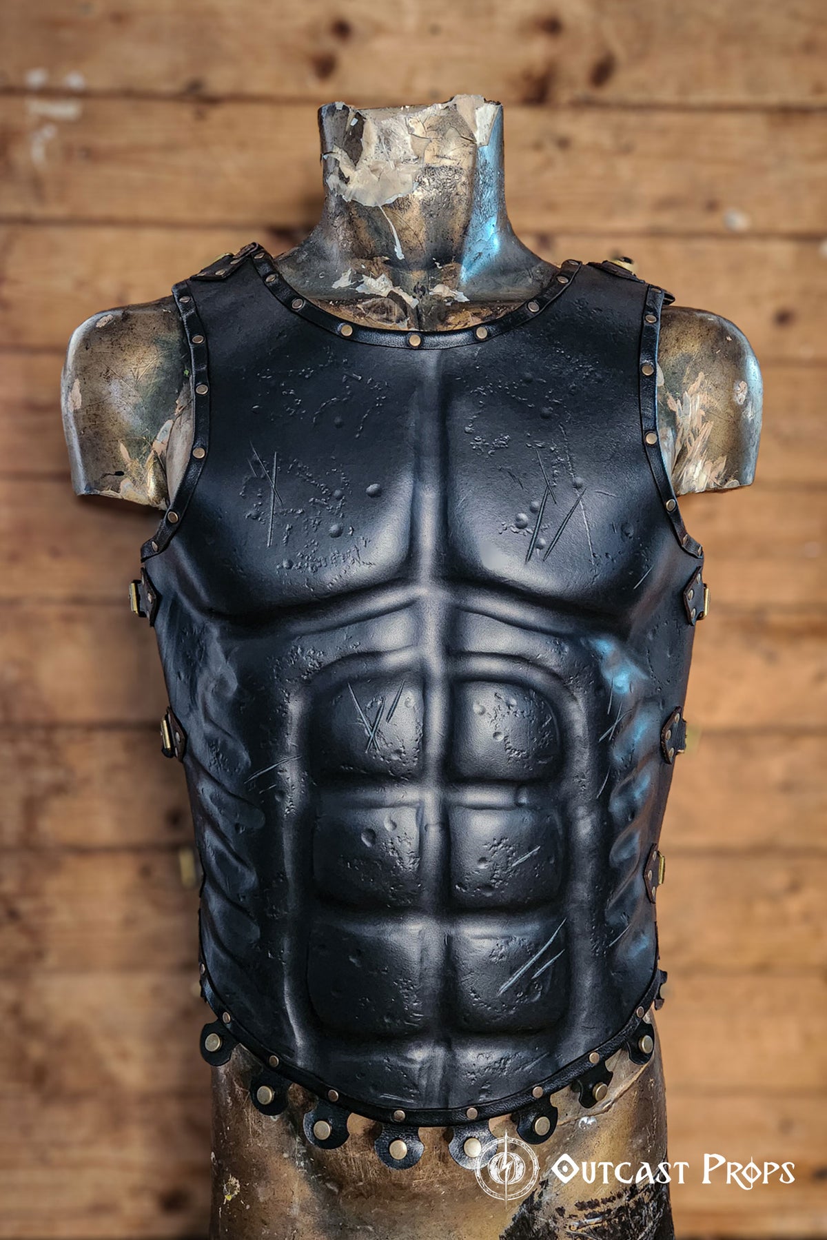 Front view of Roman leather musculata armor with visible abdominal definition, black leather surface and studded hemline. Ideal for Spartacus cosplay, Roman general costumes and medieval LARP. The muscle shaping and textured finish aid accessibility for low-vision users. Crafted with vegetable-tanned leather and hand-aged for a realistic, battle-worn look straight from history.