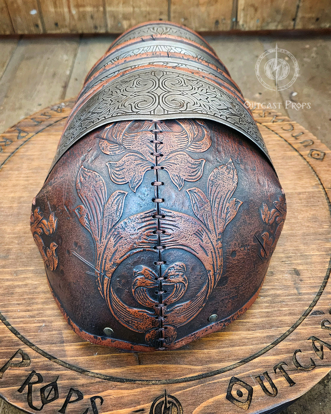Decorative tooled leather and engraved metal detail on the pauldron