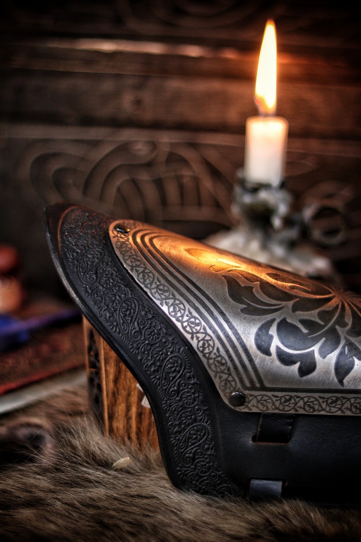 Macro close-up of the engraved floral metalwork on a fantasy black leather bracer, showing the detailed etching and high-quality leather trim. This image emphasizes craftsmanship and is perfect for showcasing handmade LARP armor or cosplay accessories with a noble or elven aesthetic.