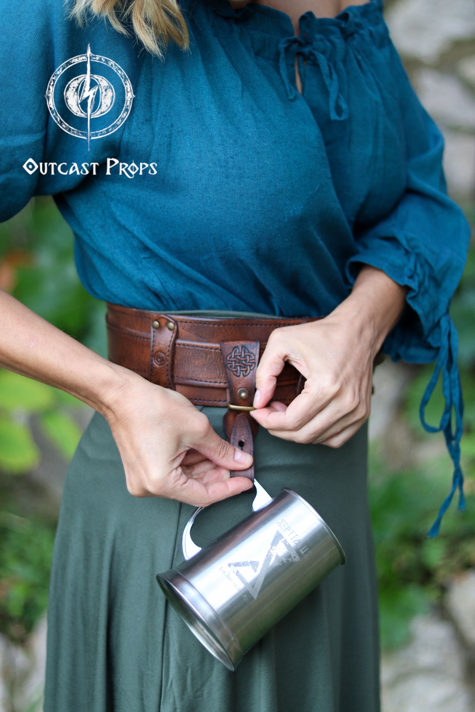 Person holding a metal mug with a leather belt and Outcast Props logo in the corner. Medieval Leather Tankard Strap: Renaissance Faire Belt up to 6 cm or 2,4 inches. Accessory for key, rope, mug. Celtic or viking costume