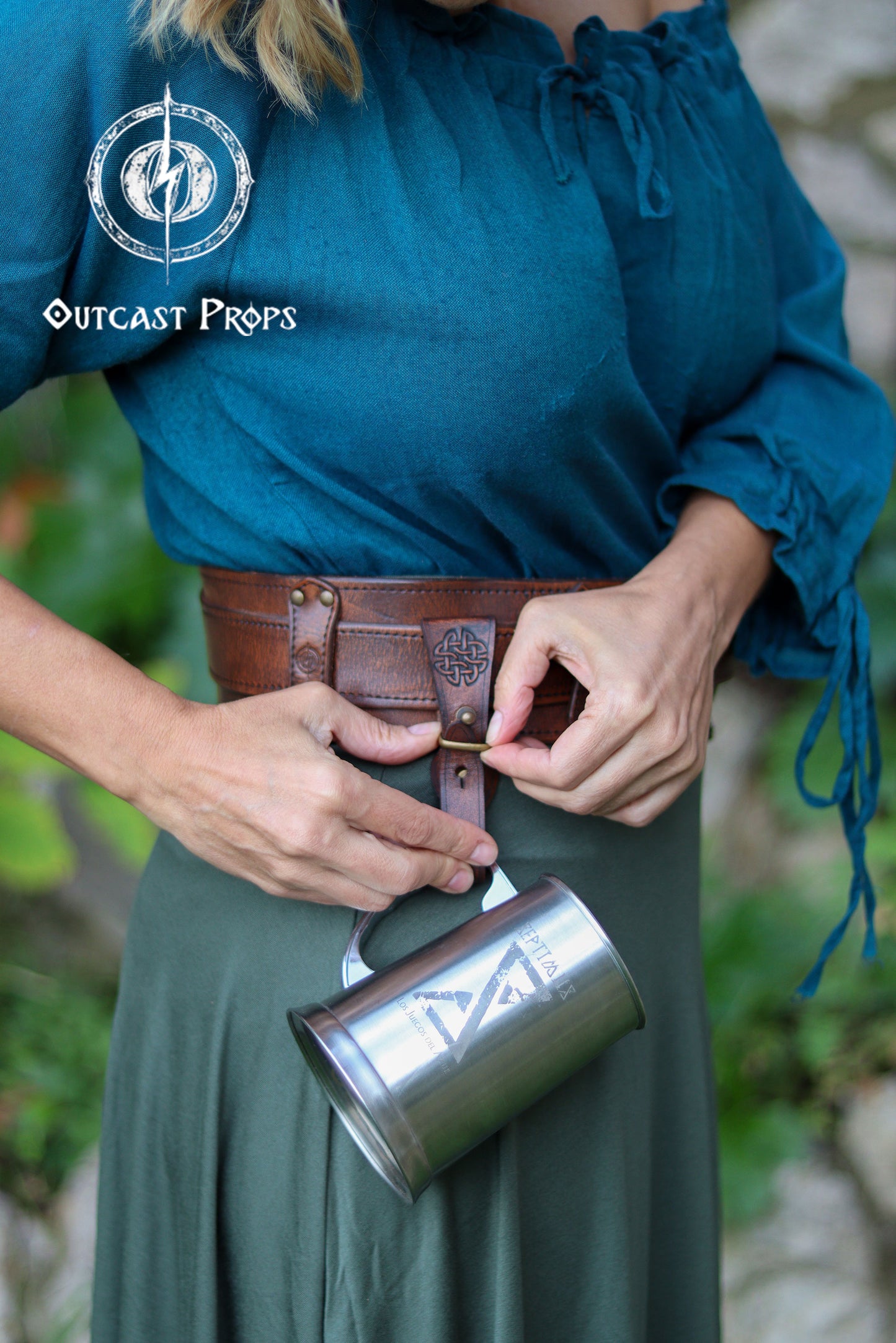 Person wearing a blue top and green skirt with a brown leather belt and silver mug, outdoors. Medieval Leather Tankard Strap: Renaissance Faire Belt up to 6 cm or 2,4 inches. Accessory for key, rope, mug. Celtic or viking costume