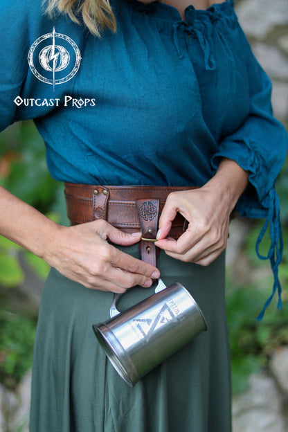 Person wearing a blue top and green skirt with a brown leather belt and silver mug, outdoors. Medieval Leather Tankard Strap: Renaissance Faire Belt up to 6 cm or 2,4 inches. Accessory for key, rope, mug. Celtic or viking costume