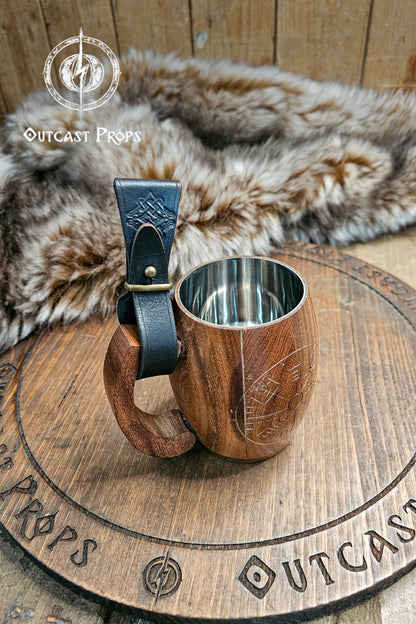 Wooden mug with leather handle on a wooden surface, branded 'Outcast Props'. Medieval Leather Tankard Strap: Renaissance Faire Belt up to 6 cm or 2,4 inches. Accessory for Viking Cosplay, LARP, and Celtic Costumes