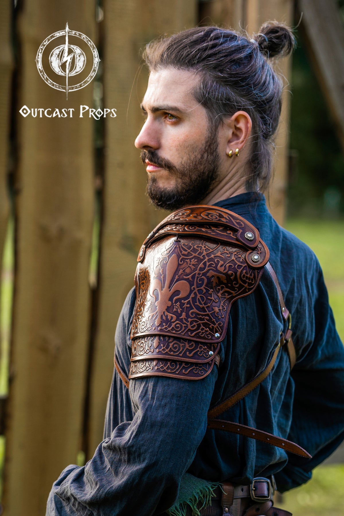 Man wearing a detailed leather shoulder piece with 'Outcast Props' logo. Leather Shoulder Pauldron: Musketeer Armor for LARP, Renaissance LARP, cosplay, Ren Faire accessory, Aramis inspired