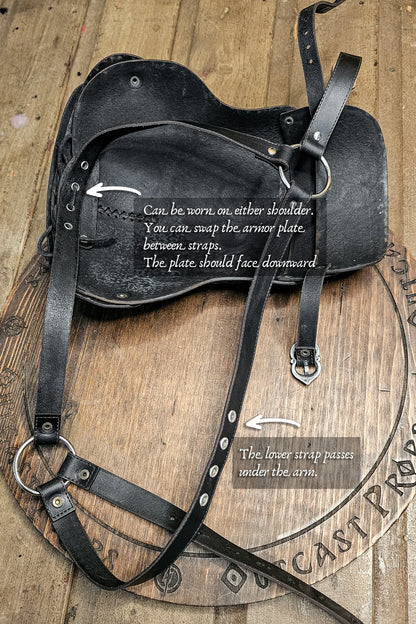 Black leather armor plate with instructions on a wooden background. Leather Shoulder Pauldron: Musketeer Armor for LARP, Renaissance LARP, cosplay, Ren Faire accessory, Aramis inspired