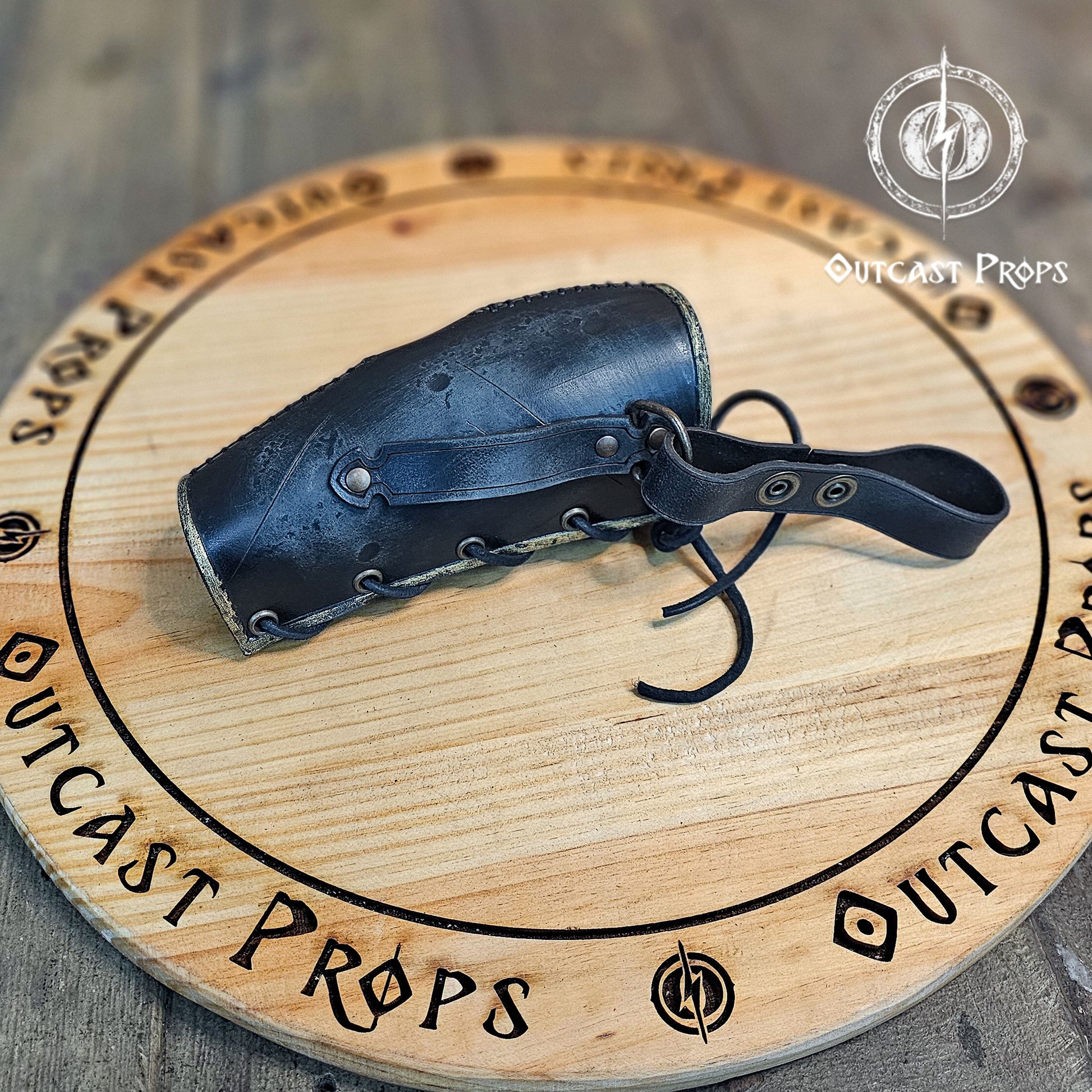 Odin Horns holder, viking horn holder made of leather belt horn holder. Decorative horn on a wooden board with 'Outcast Props' branding.