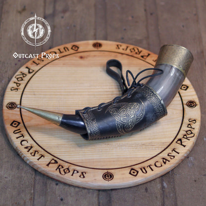 Odin Horns holder, viking horn holder made of leather belt horn holder. Decorative horn on a wooden board with 'Outcast Props' branding.