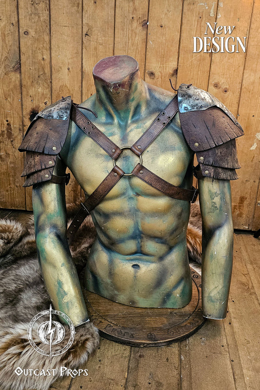 Front view of the new Outcast Props design showing the complete double pauldron armor with crossed chest harness. The layered aged brown leather and hammered steel plates blend Viking, barbarian, and ork aesthetics. Each shoulder piece connects to the adjustable harness straps, creating a durable LARP and cosplay armor handcrafted with cinematic aging and detailed craftsmanship. Barbarian Leather and Metal Pauldron Set for LARP Viking Warrior or Ork Cosplay Armor Shoulder Pads Post Apocalyptic