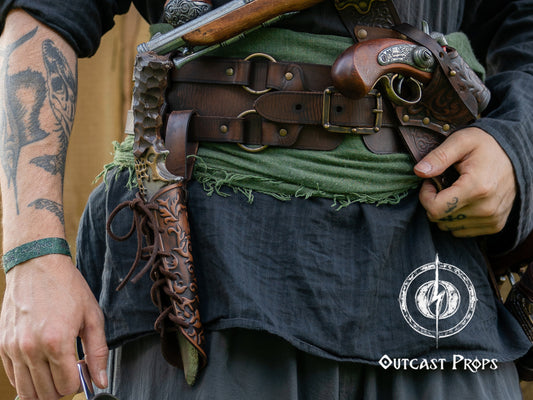 Person wearing a detailed costume with weapons and accessories, featuring 'Outcast Props' branding. Handmade leather dagger sheath | Ornate LARP scabbard | Viking, medieval, fantasy belt holster for daggers | Ren Faire cosplay accessory