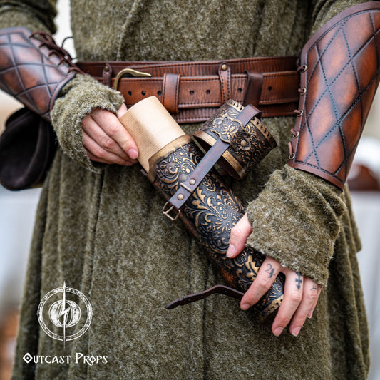 Detailed view of a fantasy scroll case being opened, revealing rolled parchment inside. The leather case is brown with golden embossed decorations, worn on the hip of a medieval-style outfit with matching bracers. Perfect LARP and Renaissance fair accessory for mages, scholars, or witches. Handcrafted with vegetable-tanned leather, perfect for storing maps, secret documents or magical scrolls.