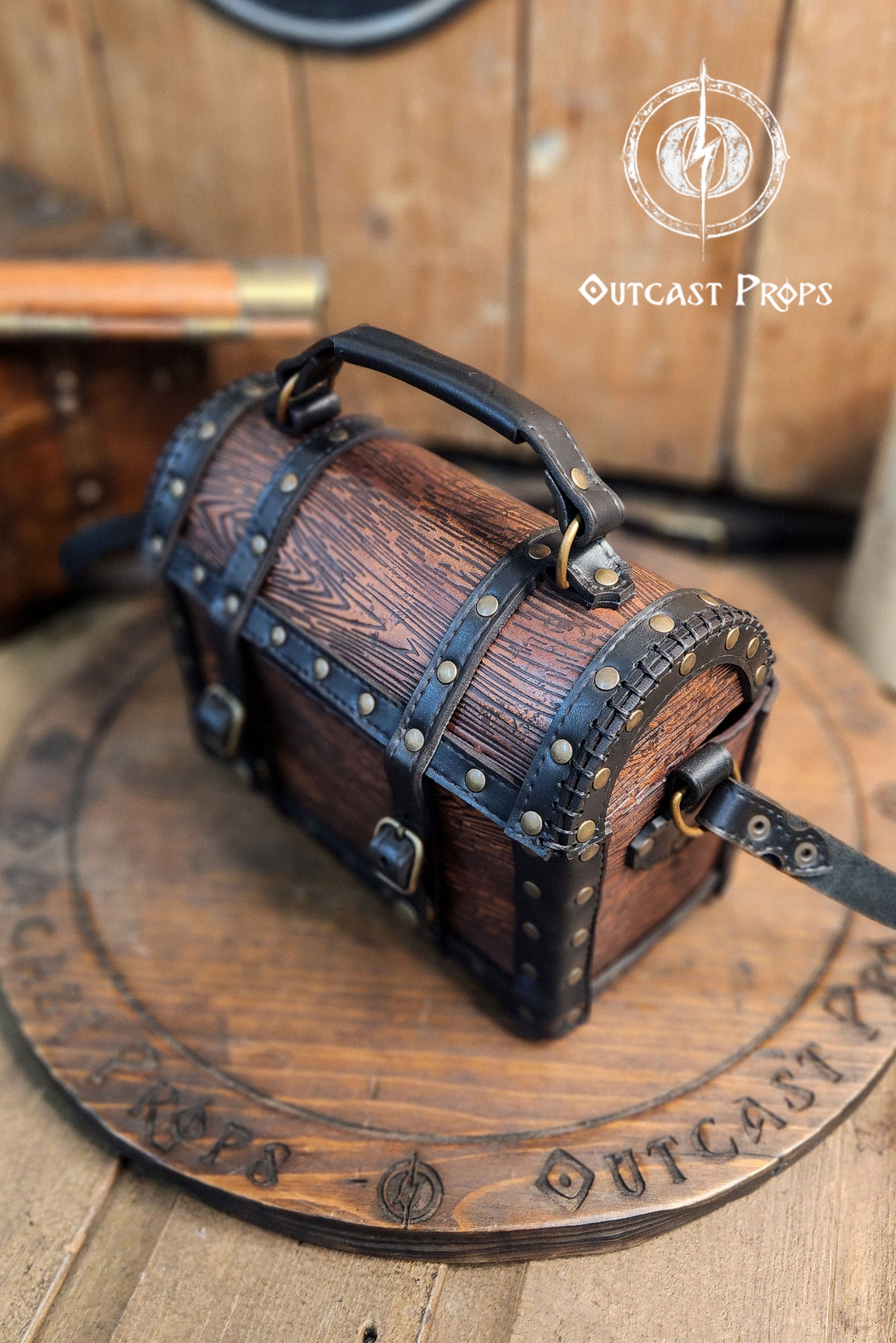 Wooden barrel-shaped bag with leather straps on a wooden surface, branded 'Outcast Props'. Leather treasure chest pirate chest bag larp pirate backpack treasure chest purse pirate accessories cosplay renfaire pouch belt bag