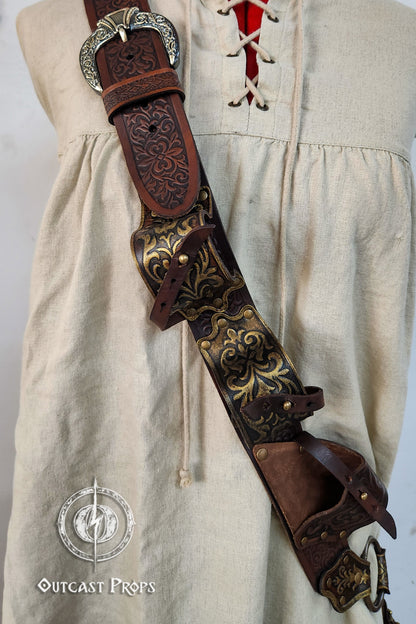 Decorative leather belt with intricate designs on a beige outfit. Pirate baldric for 4 flintlock pistols and a sword, inspired by Blackbeard, Anne Bonny, Captain Kidd and Pirates of the Caribbean. Ideal for LARP, Renfaire, renaissance fair, Pirate Weekend, cosplay, Halloween and Black Sails. Silver-engraved leather, handmade with vegetable-tanned leather. Premium pirate shoulder belt for Jack Sparrow costume, historical reenactment and fantasy events. High quality pirate accessory for themed outfits and pho