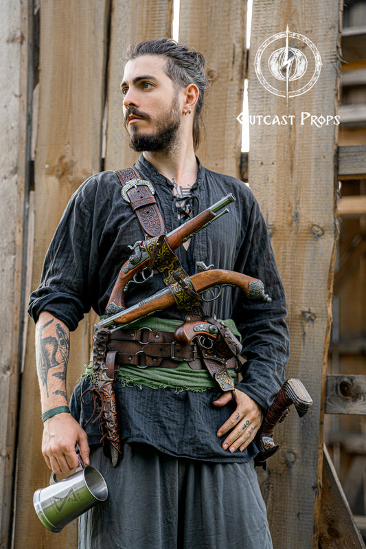 Man wearing a pirate baldric loaded with four flintlock pistols and a sword, inspired by Blackbeard and Jack Sparrow. Ideal for LARP, renaissance fair, pirate cosplay and fantasy events. Handmade from premium vegetable-tanned leather with ornate silver engraving. A perfect pirate shoulder belt for Captain Kidd or Anne Bonny outfits. Great for historical reenactment, Pirate Weekend, and themed photoshoots.
