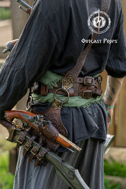 Back view of a pirate baldric showing intricate silver engravings, one flintlock pistol, and a sheathed cutlass. Inspired by historical pirates and fantasy characters, this shoulder belt is ideal for LARP, cosplay, and renaissance fairs. Crafted from premium vegetable-tanned leather with attention to detail. Perfect for Jack Sparrow, Black Sails, or Pirate Weekend looks. Great for costume design, photo sessions, and fantasy events.