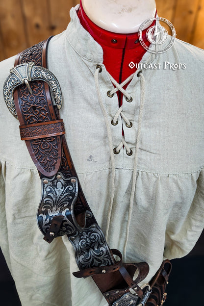 Pirate baldric for 4 flintlock pistols and a sword, inspired by Blackbeard, Anne Bonny, Captain Kidd and Pirates of the Caribbean. Ideal for LARP, Renfaire, renaissance fair, Pirate Weekend, cosplay, Halloween and Black Sails. Silver-engraved leather, handmade with vegetable-tanned leather. Premium pirate shoulder belt for Jack Sparrow costume, historical reenactment and fantasy events. High quality pirate accessory for thewearing a light-colored outfit with a detailed leather strap and decorative elements.