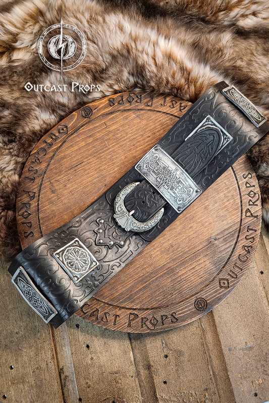 Arabic leather belt with silver plates and floral embossing, displayed over a fur pelt and engraved wooden prop. This wide leather belt is handmade in black vegetable-tanned leather with aged silver details. Perfect for arabic leather belt, fantasy leather belt, and larp belt for costume. Great for LARP, cosplay, and fantasy characters.