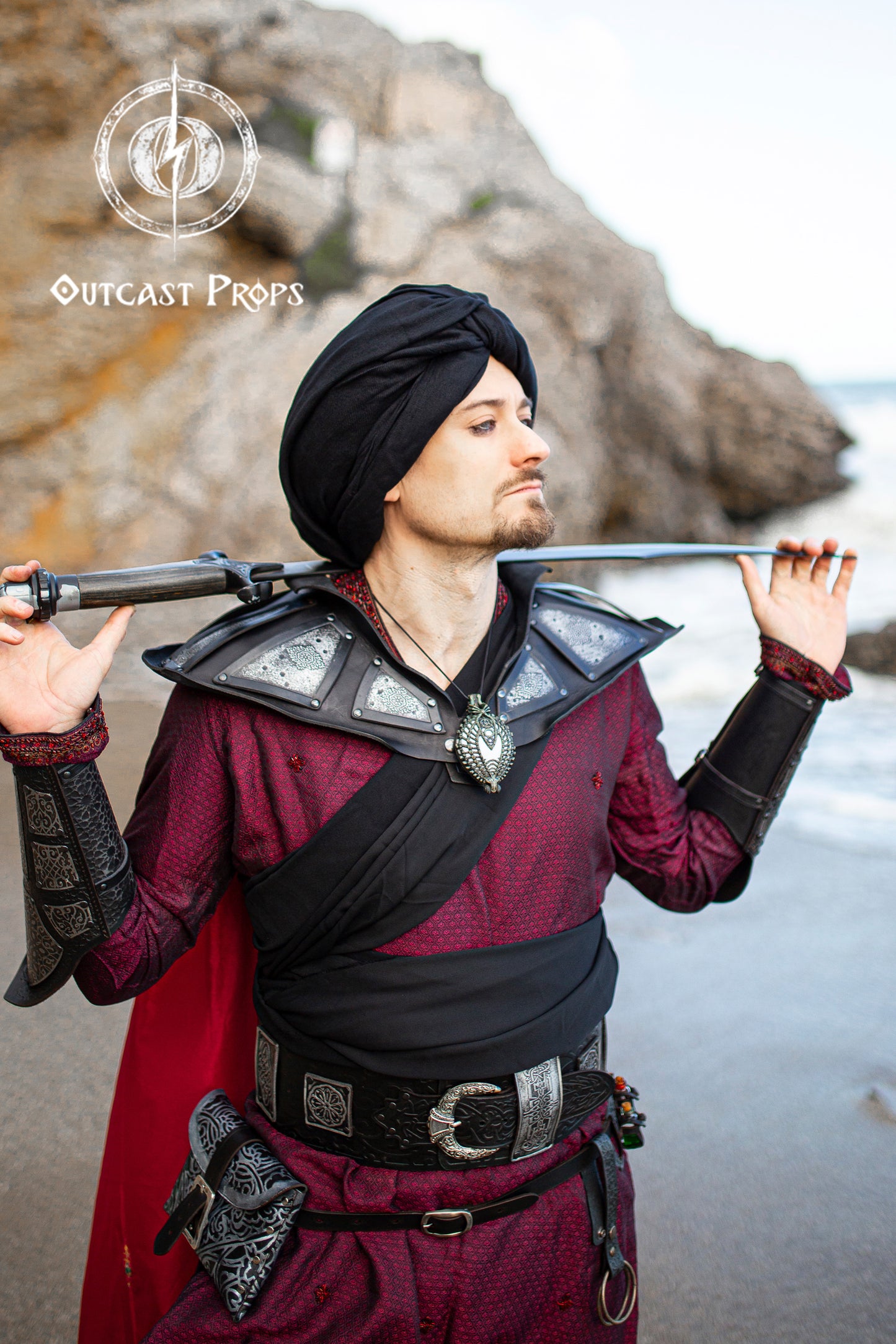 Person in medieval or fantasy costume holding a sword, Ramattush Persian Leather Broadbelt, ornamental Arabic and Persian courts inspired, larp oriental leather belt, fantasy belt, renfaire belt. Jafar cosplay costume. Aladdin cosplay.