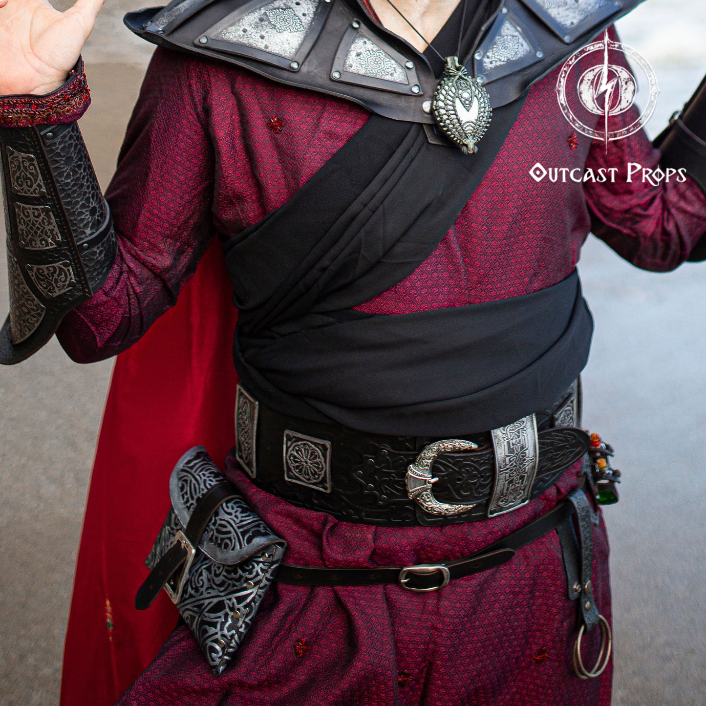 Person wearing a detailed costume with armor and Outcast Props branding. Ramattush Persian Leather Broadbelt, ornamental Arabic and Persian courts inspired, larp oriental leather belt, fantasy belt, renfaire belt. Jafar cosplay costume. Aladdin cosplay.