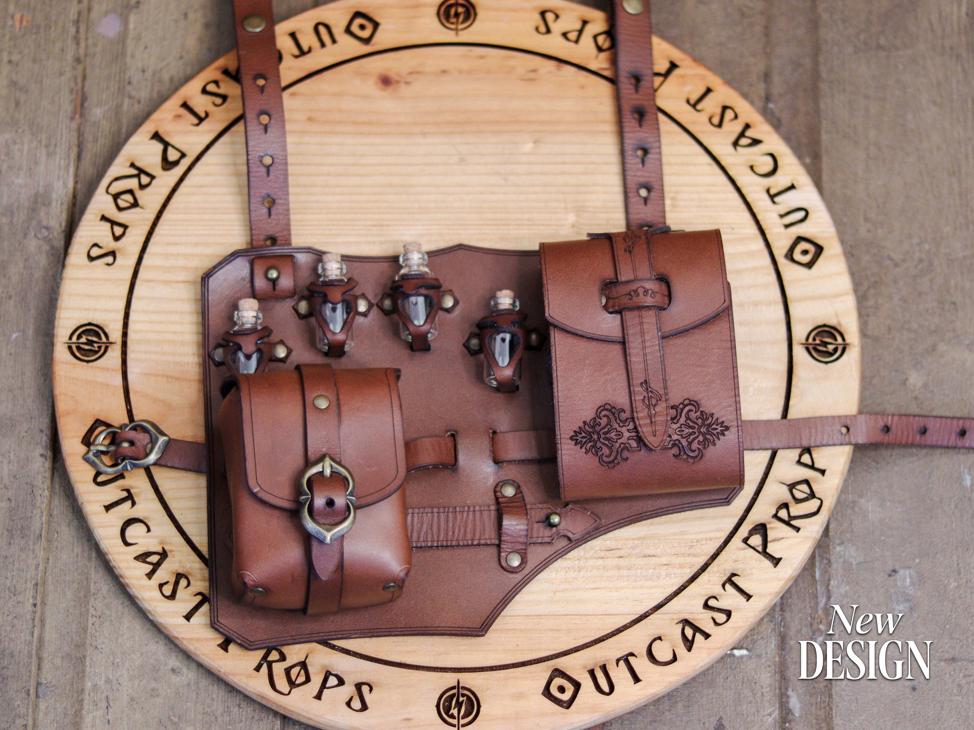 Top view of the brown leather leg holster showing both pouches and potion vials on a wooden Outcast Props board. Handcrafted from vegetable-tanned leather with antique brass buckles and embossed details. Designed for rogues, alchemists, and adventurers, this fantasy accessory for LARP, cosplay, and renaissance fairs combines functionality, adjustability, and authentic medieval craftsmanship for immersive costumes.