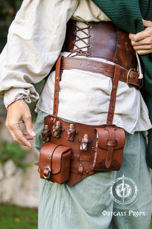 Close up of the upgraded leather leg harness potion belt worn over loose fantasy trousers. The shot highlights the modular design with reinforced straps, thigh attachment, potion vials in carved holders and a book holster style side pocket. Rich brown vegetable tanned leather with aged finish evokes steampunk and alchemist gear. Ideal for LARP adventurers, rogues and herbalists who need a functional larp belt or potion belt that keeps essentials secure during movement.