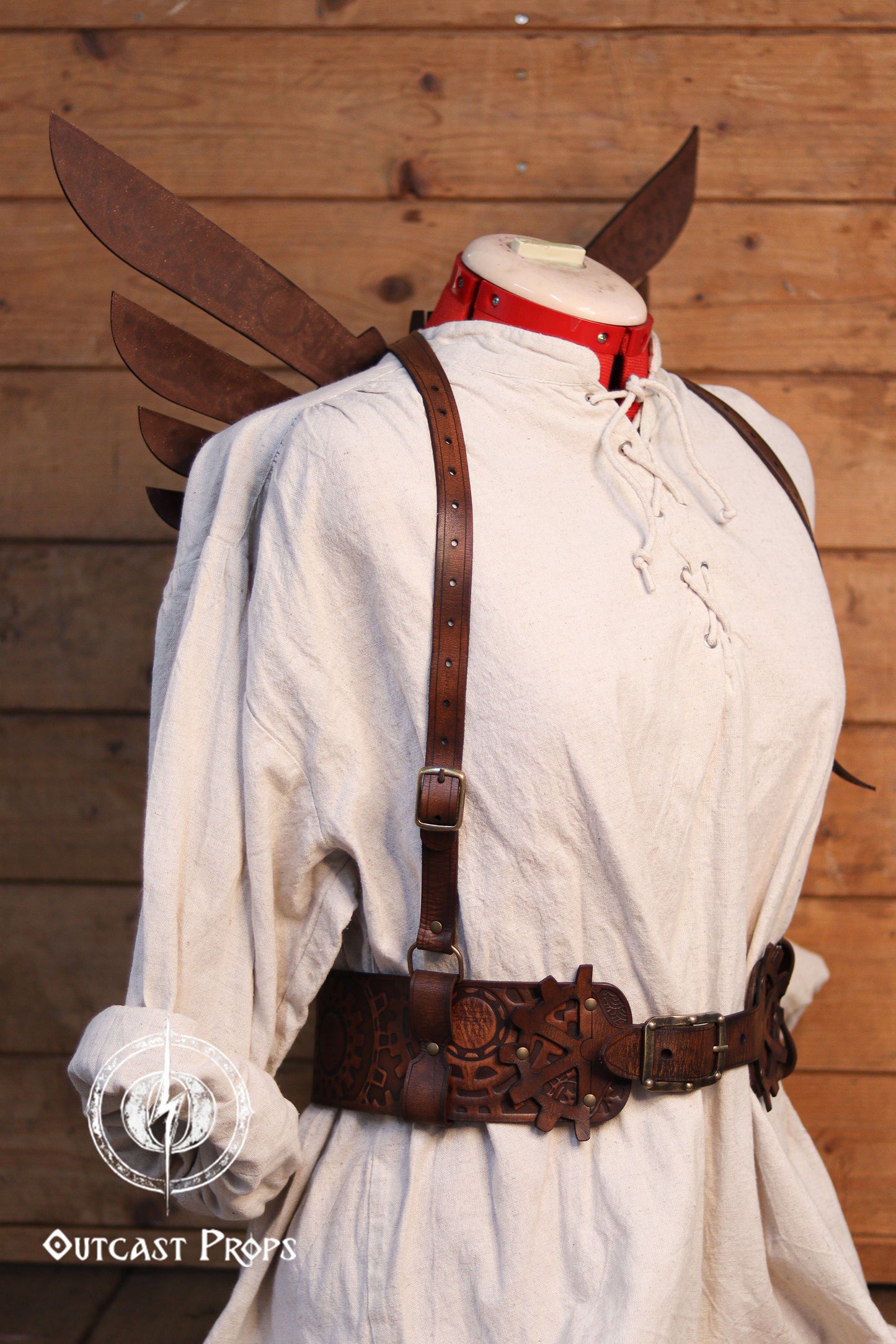 Mannequin wearing a white shirt with leather straps and wings against a wooden background. Steampunk Wings leather gears fairy victorian outfit burning man aviator pin up costume clock