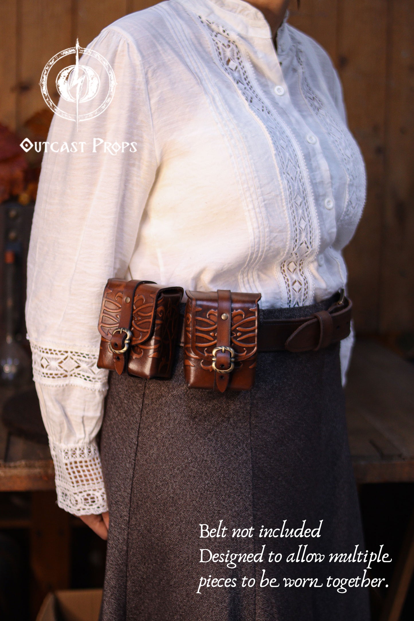 Two ornated leather belt pouches worn together on a waist belt, demonstrating modular design that allows multiple pieces to be worn side by side. Made from vegetable-tanned leather with hand-embossed details, these medieval leather tobacco bags are perfect for fantasy outfits, LARP gear, or as a unique handmade gift for lovers of artisan leather accessories. Person wearing a white blouse with lace details and a brown belt with pouches, with 'Outcast Props' branding.