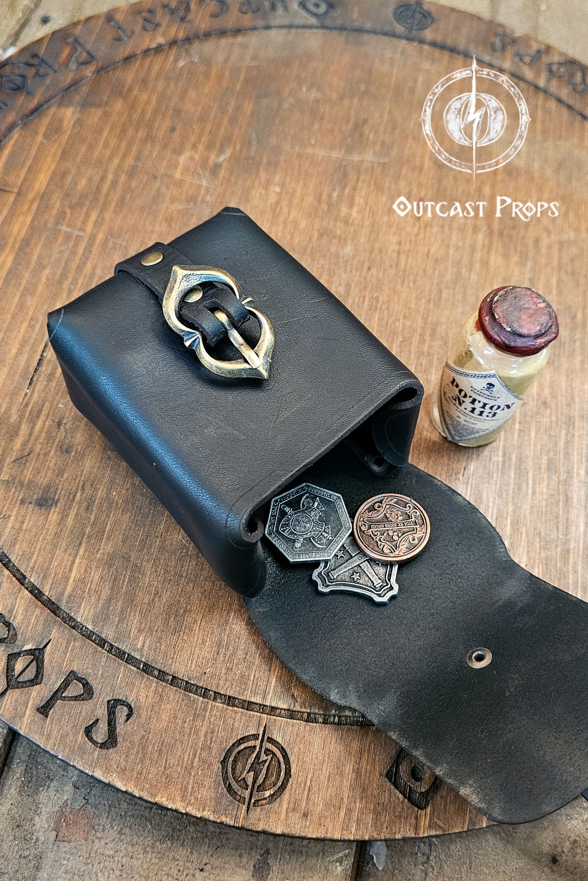 Tavern Small Leather Belt Pouch for Daily Wear LARP Renaissance Fair Viking Cosplay Medieval Accessory Steampunk Coin or Tobacco Pouch. Black leather pouch with metallic coins on a wooden surface, featuring 'Outcast Props' branding.
