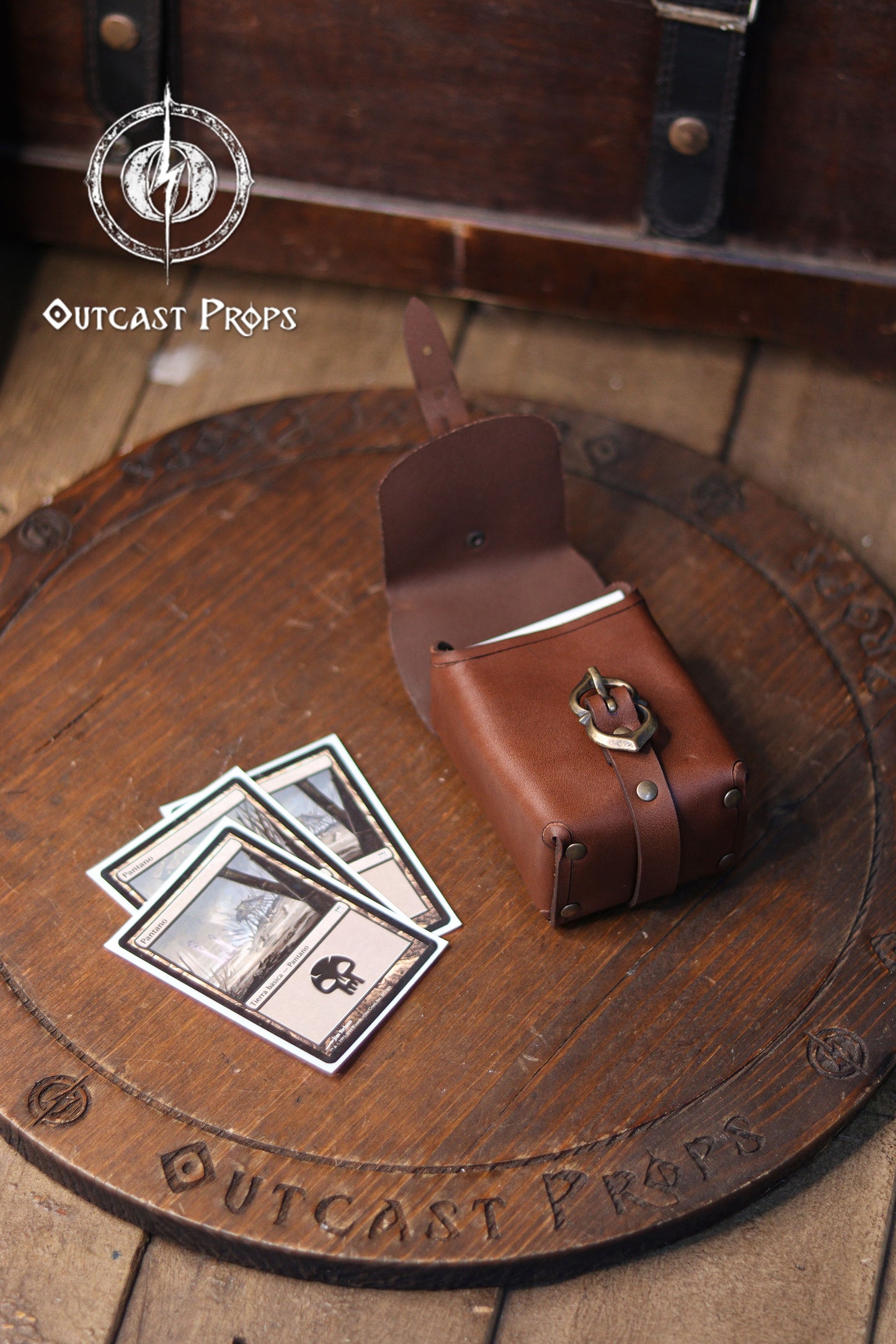 Small leather belt pouch crafted from full grain vegetable tanned leather, photographed partially open and filled with a deck of cards. This medieval style pouch works as a practical deck bag for Magic The Gathering, Pokémon, Arkham Horror, and other popular card games. The reinforced shape and brass buckle closure keep cards secure while worn on the belt. Inspired by tavern accessories and historical gear, it is also ideal for carrying coins, keys, dice, earbuds, or a tobacco pack. Perfect for LARP, Renais