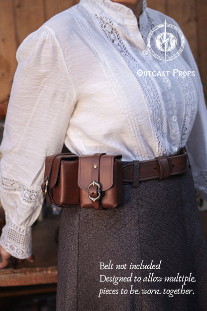 Side view of a handcrafted leather belt pouch worn at the waist, highlighting its curved shape, reinforced seams, and solid brass buckle. Made from premium vegetable tanned leather, this medieval pouch functions as a compact deck holder for Magic The Gathering, Pokémon, and Arkham Horror cards. Its belt mounted design allows hands free use during games, events, or conventions. Also suitable for coins, dice, lighters, keys, or tobacco. Designed to be worn together with other matching leather belt pouches fro