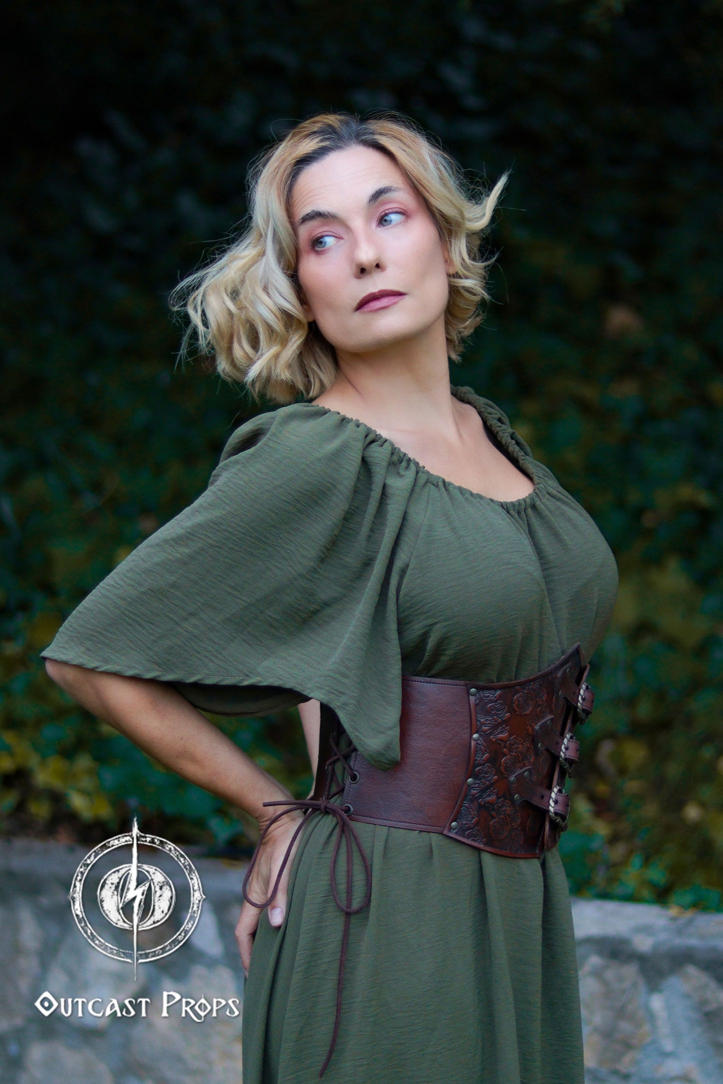 Woman wearing a green dress with a brown belt against a natural background. Elegant Floral Underbust Leather Corset - Handcrafted Rose Design for Larp, Reinassande Faire &amp; Cosplay