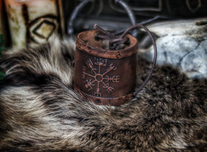 A brown leather wristband with a Viking compass design, displayed on a furry surface, featuring intricate handcrafted details. Vegvisir Leather Wristband, Galdrastafir Viking Bracelet,  Icelandic way finder rune leather embossed cuff, LARP, cosplay