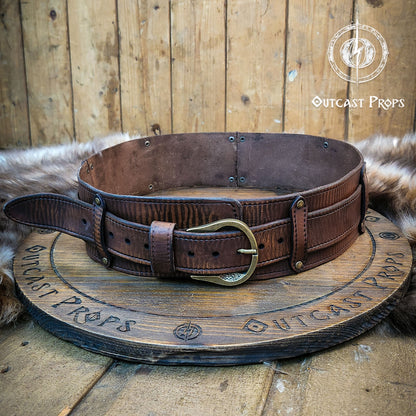 Brown leather belt with brass buckle on a wooden surface, branded 'Outcast Props'. Medieval broadbelt for larp or cosplay. Elegant leather belt. Celtic knot leather belt silver buckle larp belt for ren fair fantasy costume celtic belt unisex leather belt for renaissance outfit
