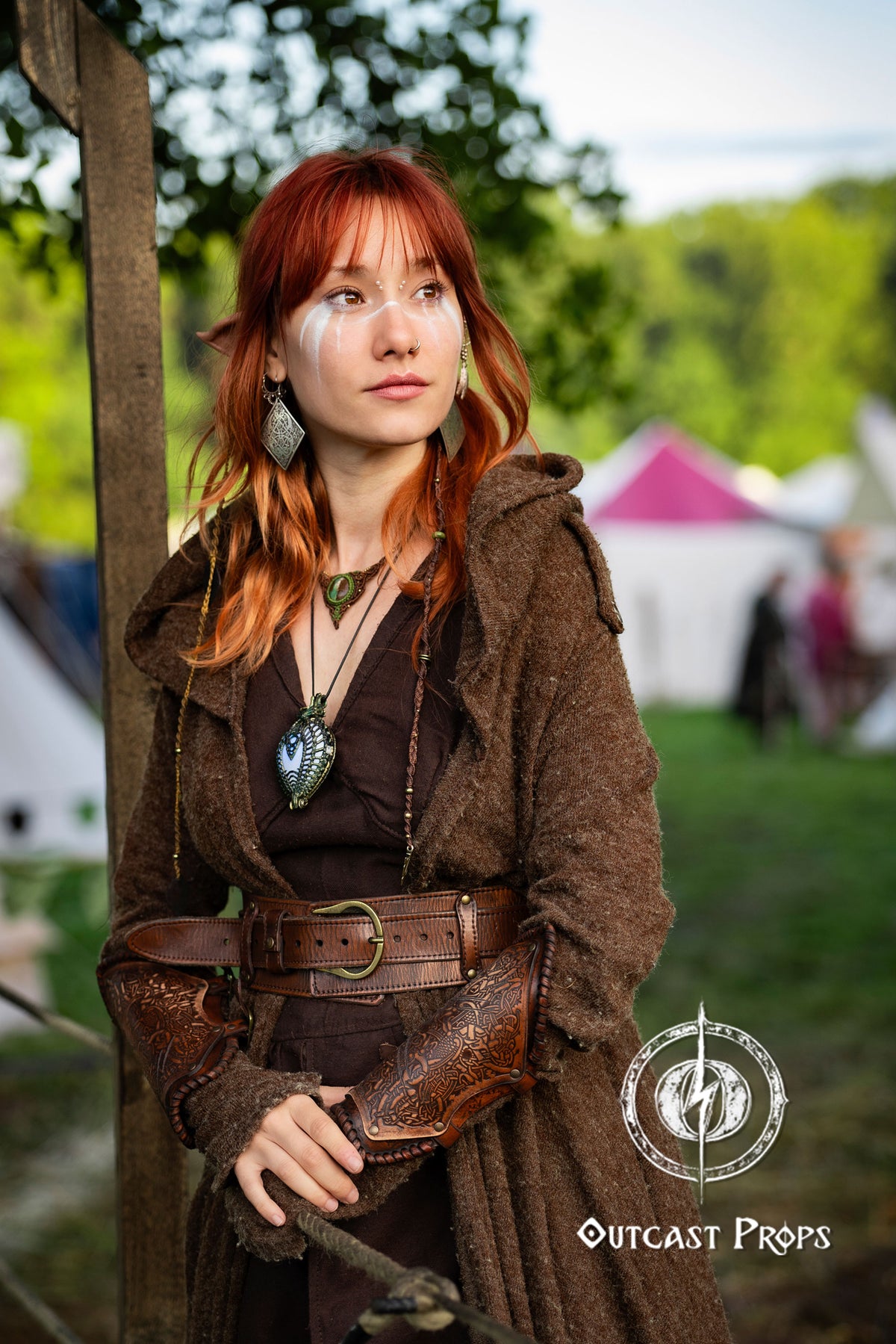Person in medieval or fantasy costume with red hair and Outcast Props logo. Viking Leather Bracers with Norse Knot Engraving for LARP Cosplay Medieval Fantasy Roleplay Handmade Armor Custom Gear for Men or Women