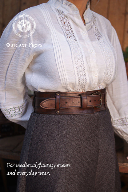 Angled front view of the Handcrafted Leather Wanderer Belt worn at the waist, showing the wide leather frame and brass buckle from a different perspective. The premium vegetable-tanned leather features visible grain, hand-finished edges, and subtle aging. A modular two-piece belt designed to suit medieval, fantasy, and LARP costumes while remaining refined enough for modern everyday wear. 
