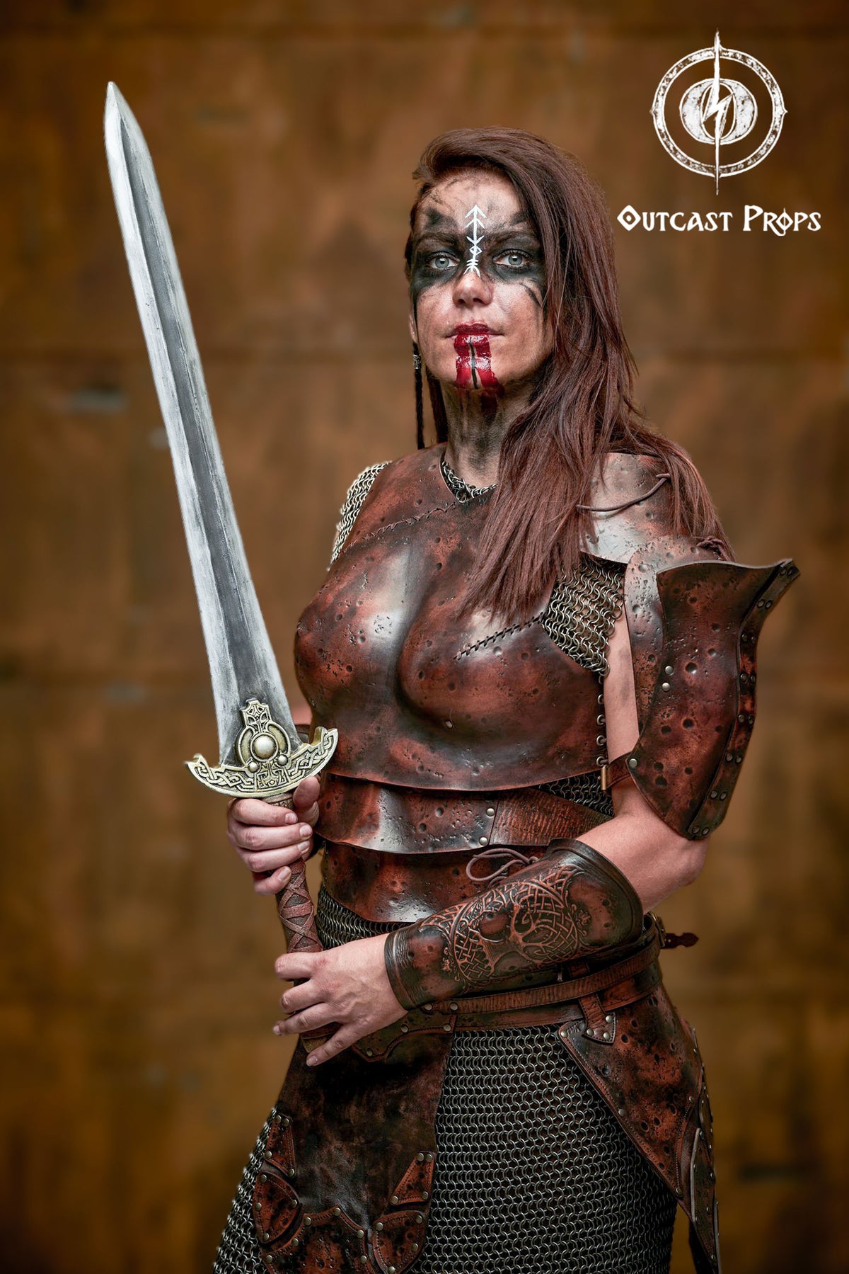 Viking leather armor women set worn by a warrior woman with blood and warpaint. Handcrafted breastplate and tassets in distressed leather create a powerful fantasy warrior costume for LARP, cosplay or medieval events. Detailed texture and chainmail enhance its realism.