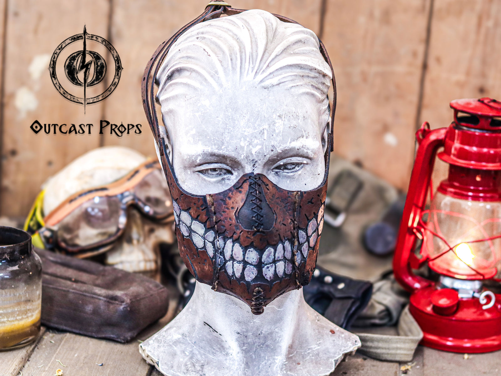 Skull-themed mask on a mannequin head with rustic background and lantern. Zombie Leather Face Mask walking dead bitters, for cosplay or bikers. Can be used with disposable face masks, filters or washable masks