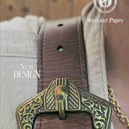 Close shot of the leather baldric holsters holding two decorative flintlocks. The leather straps are heavily embossed with scroll and leaf designs, and feature bronze-toned hardware for a period-authentic pirate look. Ideal for LARP, cosplay, or fantasy festivals. Crafted from hand-dyed leather with reinforced stitching. Holsters are designed to accommodate various sizes of replica pistols for immersive character play.