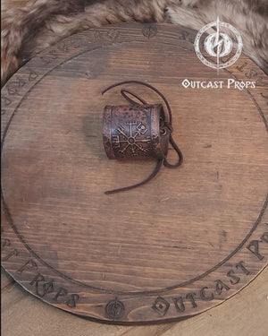 A brown leather wristband with a Viking compass design, displayed on a furry surface, featuring intricate handcrafted details. Vegvisir Leather Wristband, Galdrastafir Viking Bracelet,  Icelandic way finder rune leather embossed cuff, LARP, cosplay