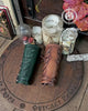 Two leaf elven bracers displayed on a carved wooden board with the Outcast Props logo. Their embossed leaf pattern and aged leather finish show craftsmanship ideal for renaissance faire costumes, larp characters, elves, witches, herbalists or fae themed outfits. These leather bracers also complement roman laurel or Caesar cosplay thanks to the leaf motif. Laced fastening and warm tones highlight their elegant look.