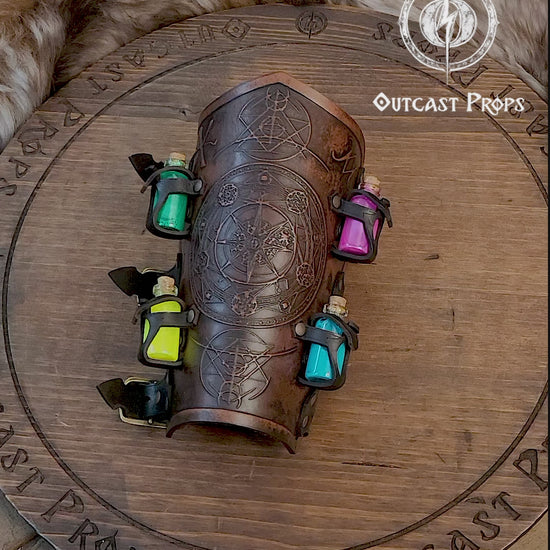 A leather bracer with metal rivets and straps, featuring intricate alchemical circles and small glass vials for storing liquids. Alchemist leather bracer with transmutation circle larp armor Wizards sorcerers and masters of the occult and the arcane