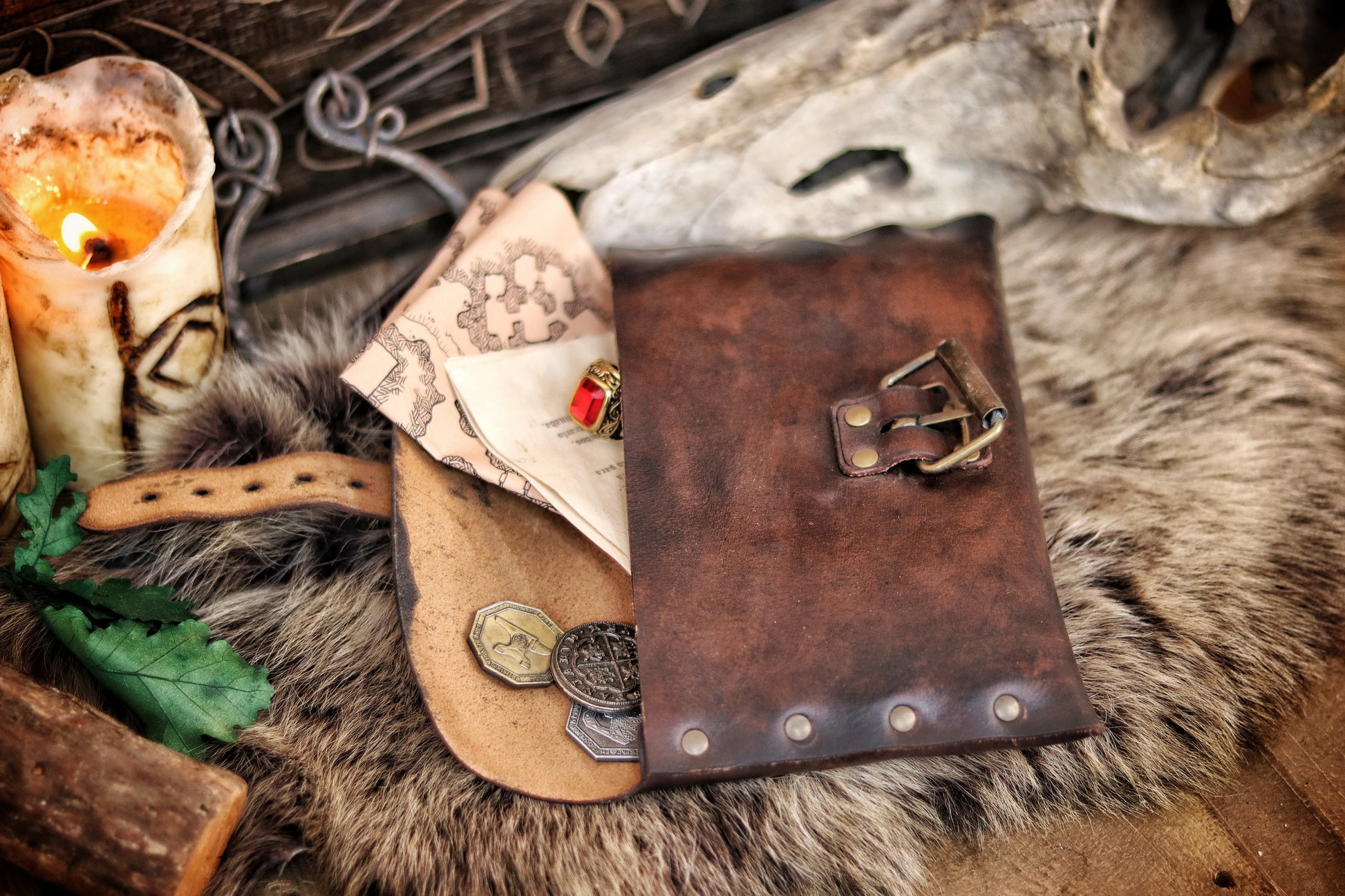 Open medieval leather pouch with brass buckle, revealing fantasy maps and scrolls inside. Ideal LARP document pouch or Renaissance fair accessory. Crafted from distressed brown leather, lying on fur with candlelight. Great for scribes, messengers, or immersive character props. Long tail optimized for handmade leather pouch with documents.