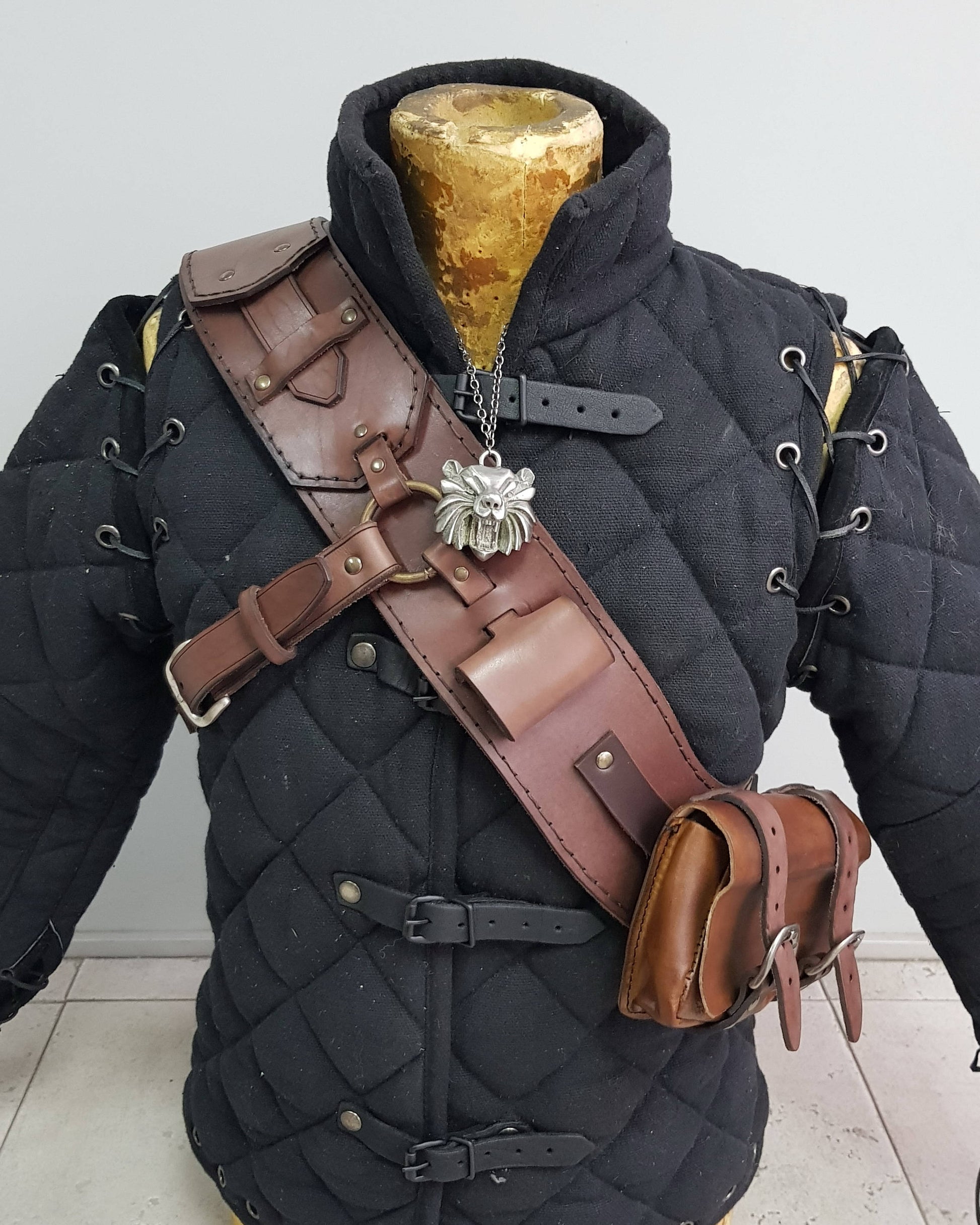 Leather baldric inspired by Witcher 3 ursine armor, handcrafted with brown leather and functional pouches, worn over padded gambeson. Ideal for witcher cosplay, Geralt costume, LARP armor, and fantasy RPG outfits. A premium bear school leather bandolier and monster hunter gear accessory for witcher costume builds.