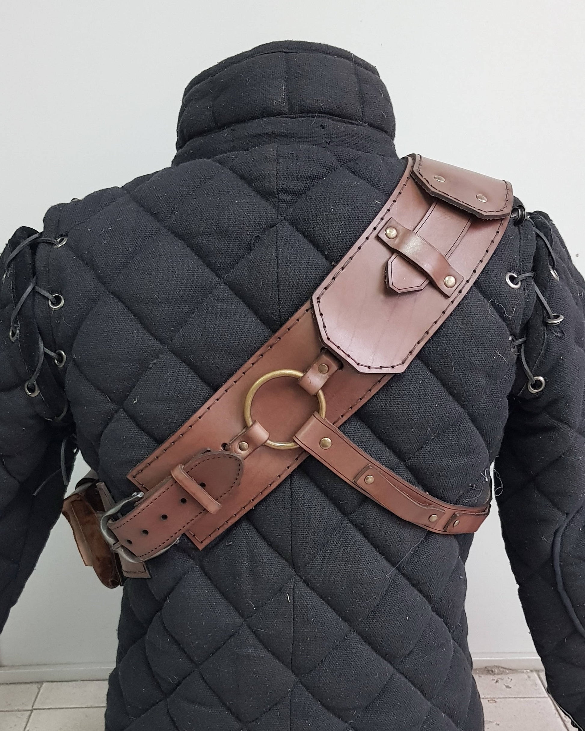 Witcher ursine armor leather baldric, back side view. Features solid stitching, adjustable straps, and iconic metal ring system. An authentic leather baldric for Witcher cosplay, Geralt LARP gear, fantasy RPGs and bear school inspired Witcher costume builds.