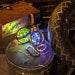 Close-up of two glowing Magic Light Potion Bottles with colorful LED lights inside, wrapped in steampunk-style leather straps. Perfect for LARP, cosplay, Burning Man, or mad scientist costumes. 250ml PET plastic bottles, belt loop included, battery operated with safe LR44 alkaline batteries for aerial transport.